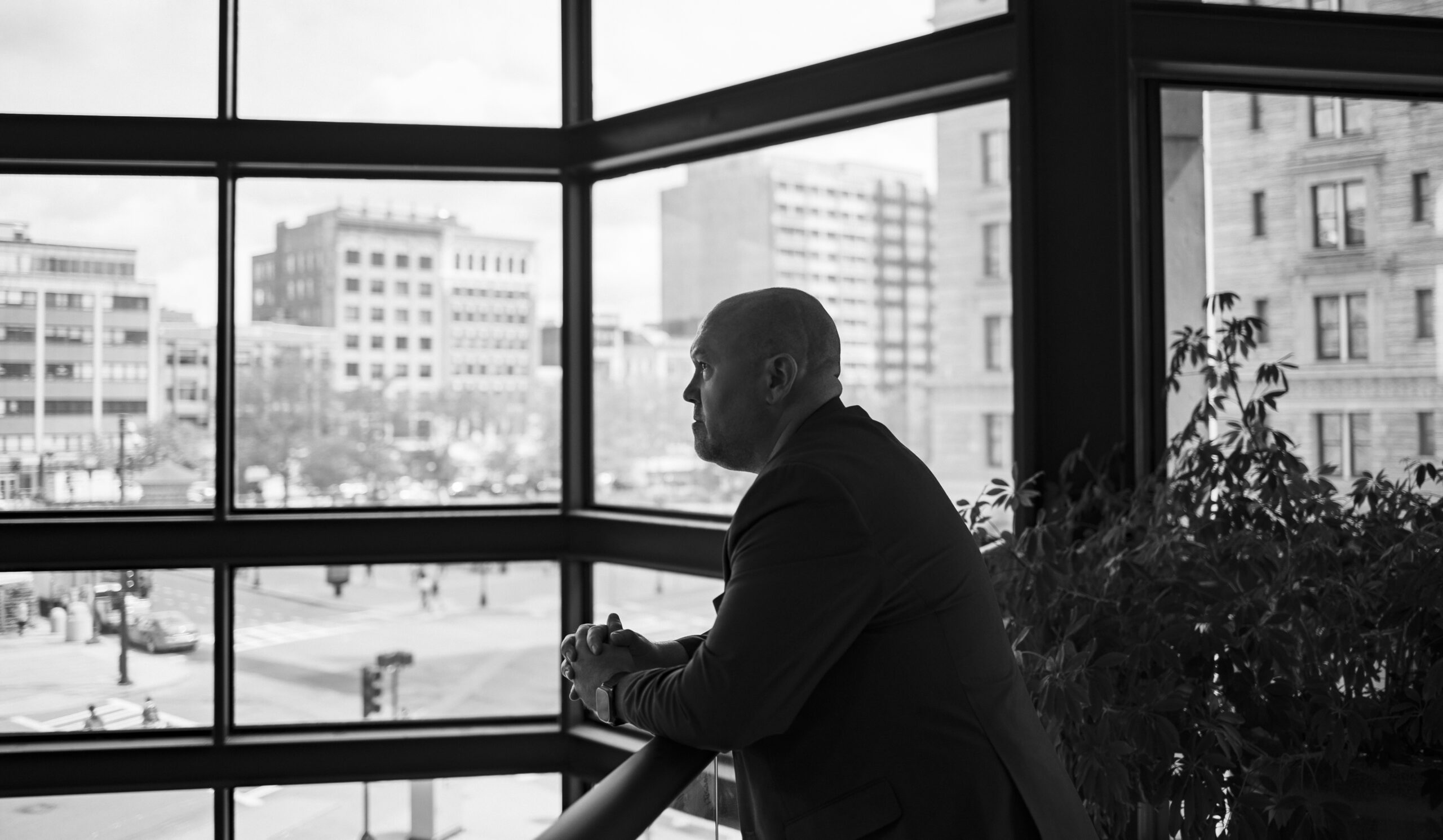 Nate Motyl global executive and corporate fixer in a building in Boston looking over a railing.